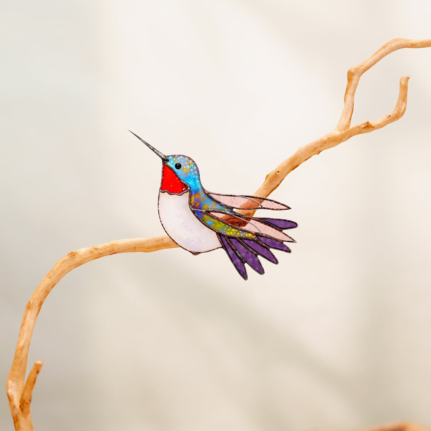 Ruby-throated hummingbird stained glass clip decor attached to a plant