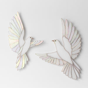 Two white dove wall decorations with iridescent pastel wings, shown on a clean white background.